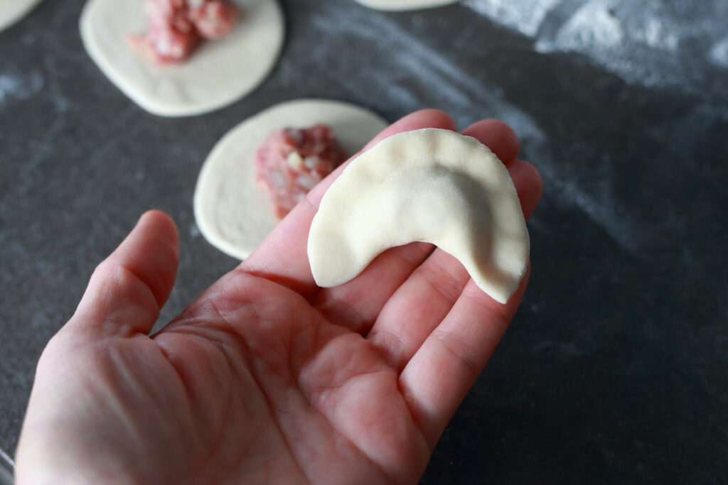 Folded pelmeni in a hand