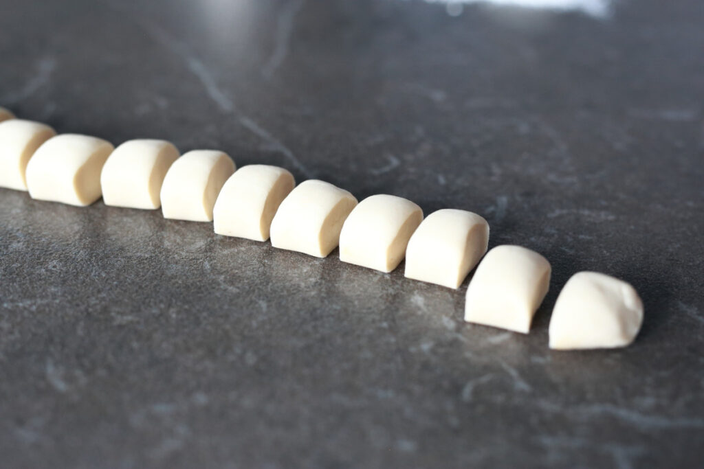 Pelmeni dough sausage cut into small pieces.