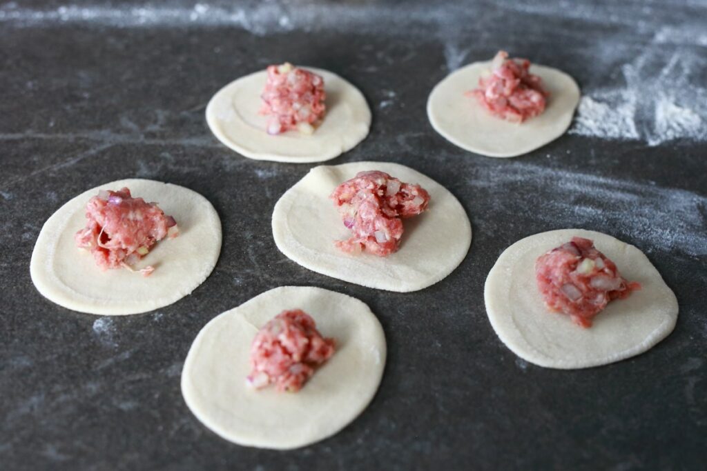 Rolled out pelmeni dough with meat filling