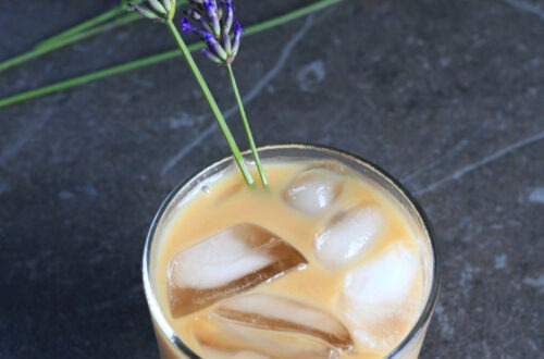 Honey Lavender Cold Brew coffee served in a glass with sprigs of lavender.