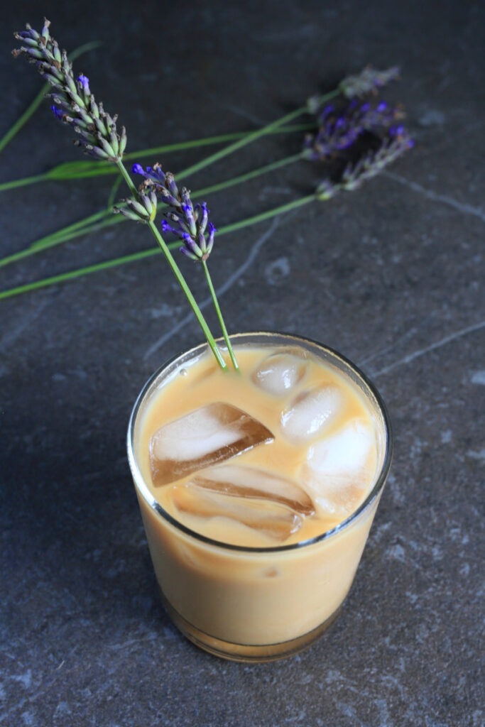 Honey Lavender Cold Brew coffee served in a glass with sprigs of lavender.