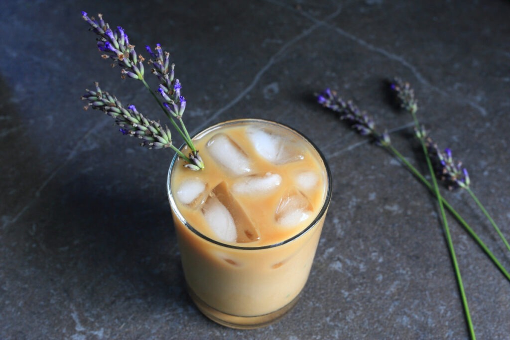 Honey Lavender Cold Brew coffee served in a glass with sprigs of lavender.