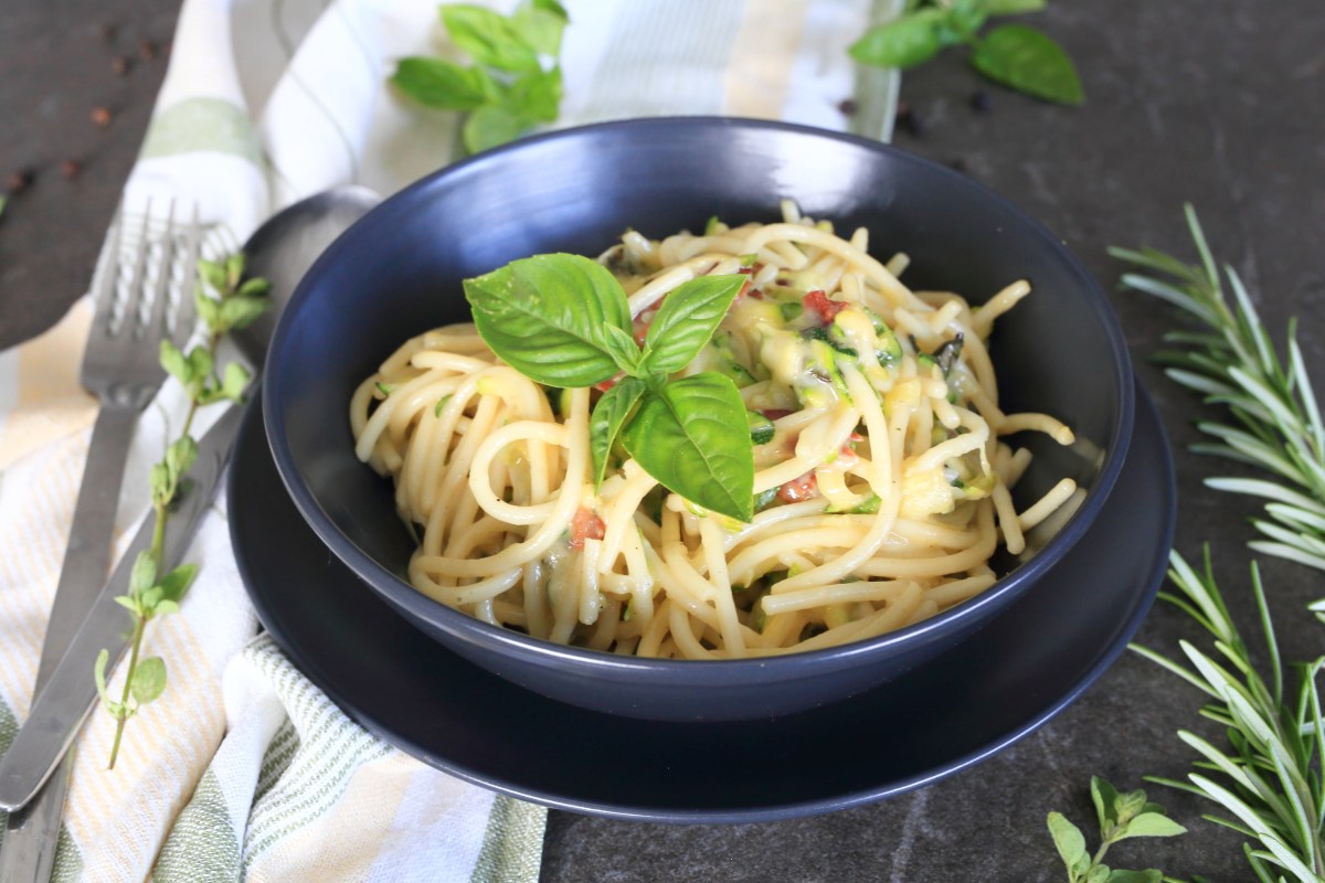 Zucchini pasta with Gouda served in a charcoal bowl.