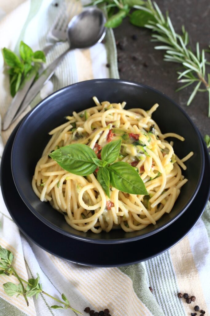 Zucchini pasta with bacon and gouda served on a plate.