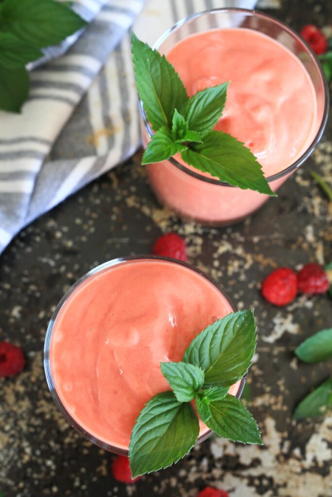 Smoothie mit Mango served in a glass with mint leaves.