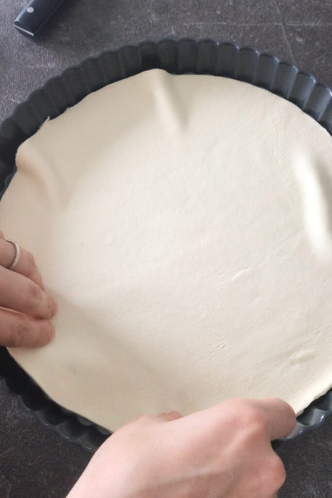 Place puff pastry dough into tart pan.