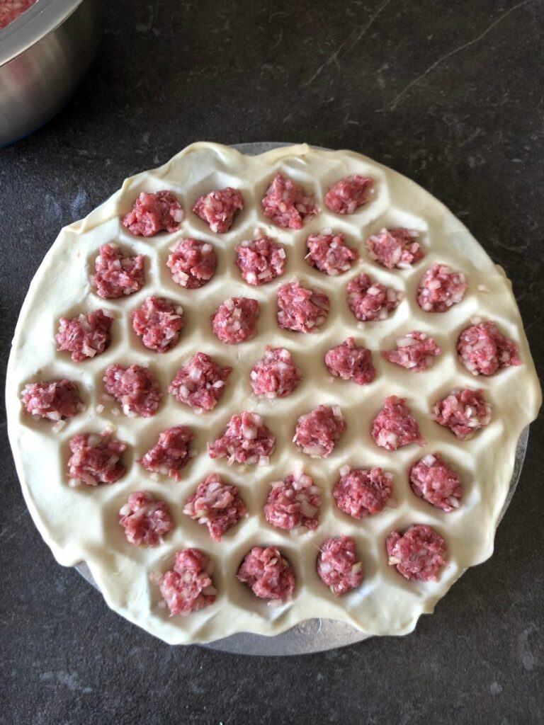 Meat filling added to pelmenitsa for pelmeni