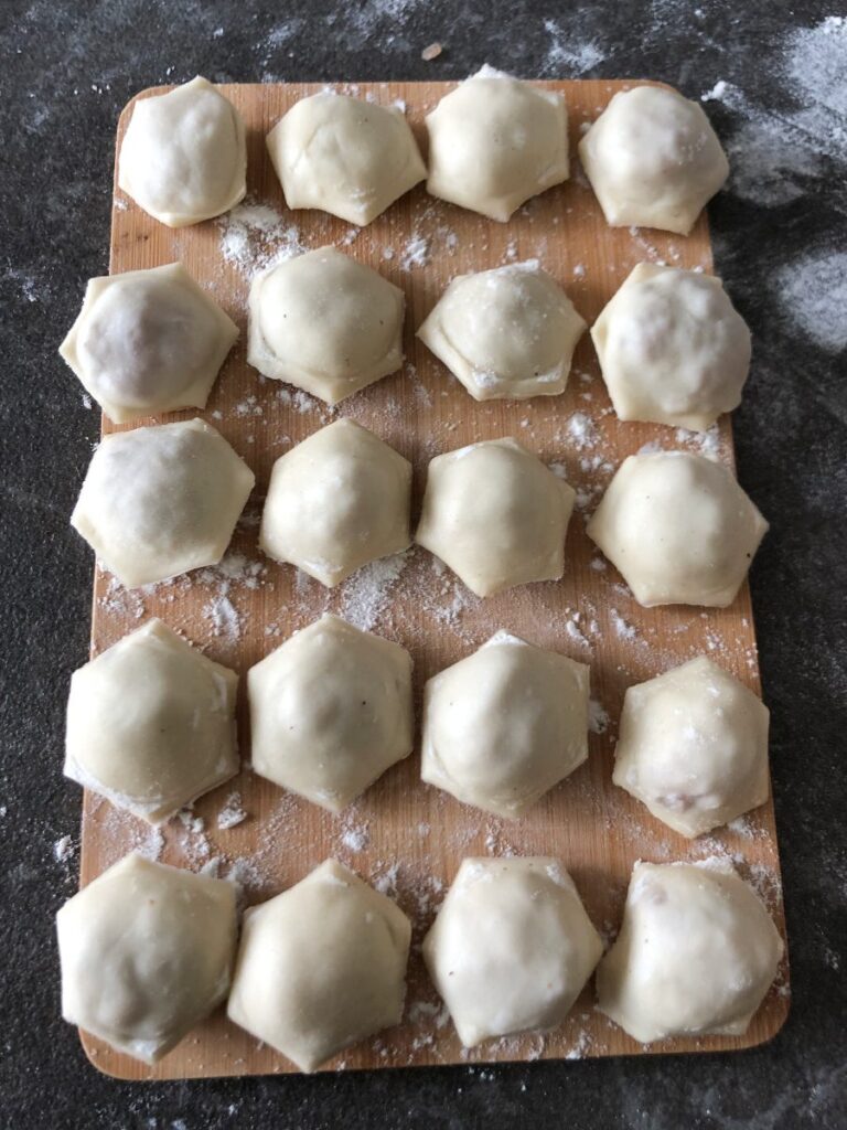 Pelmeni meat dumplings on a bamboo board