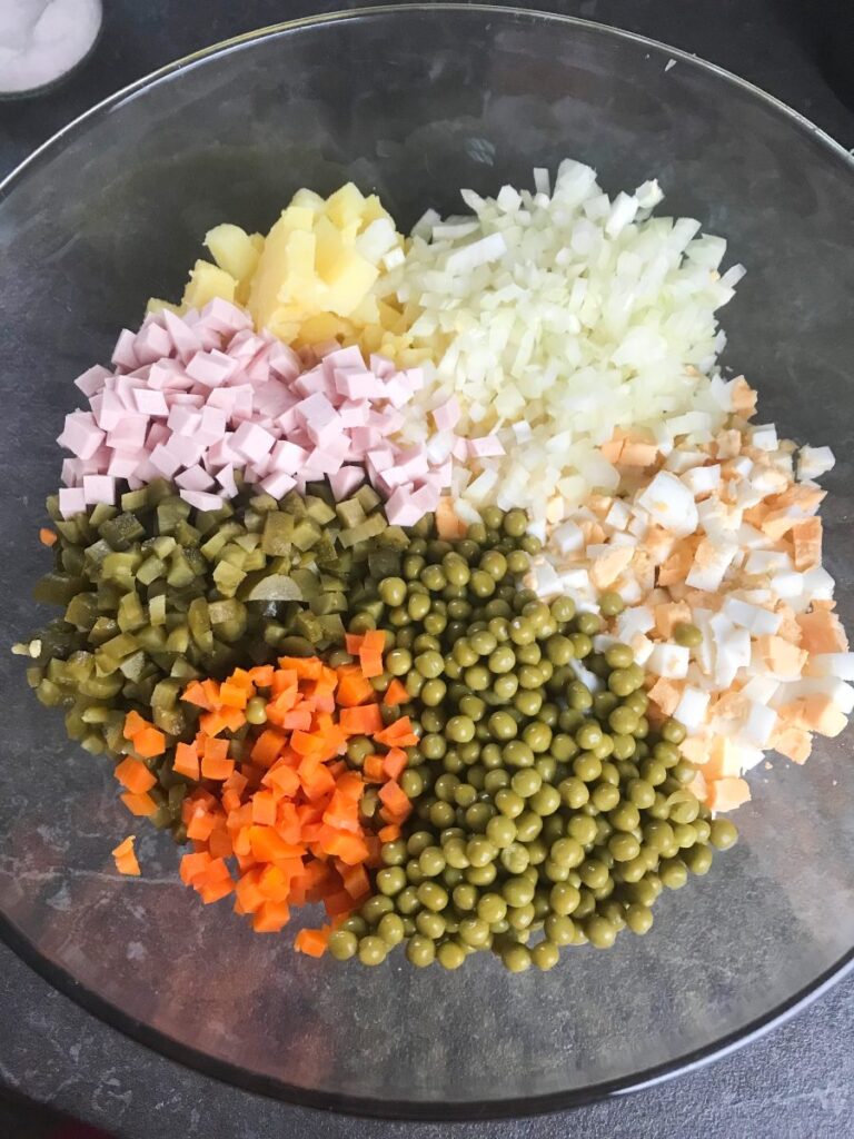 Chopped olivye potato salad ingredients in a bowl