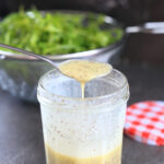 Poppy seed dressing with honey prepared in a jar.