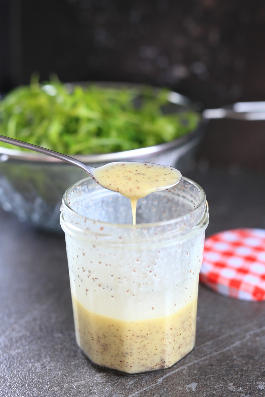 Poppy seed dressing with honey prepared in a jar.