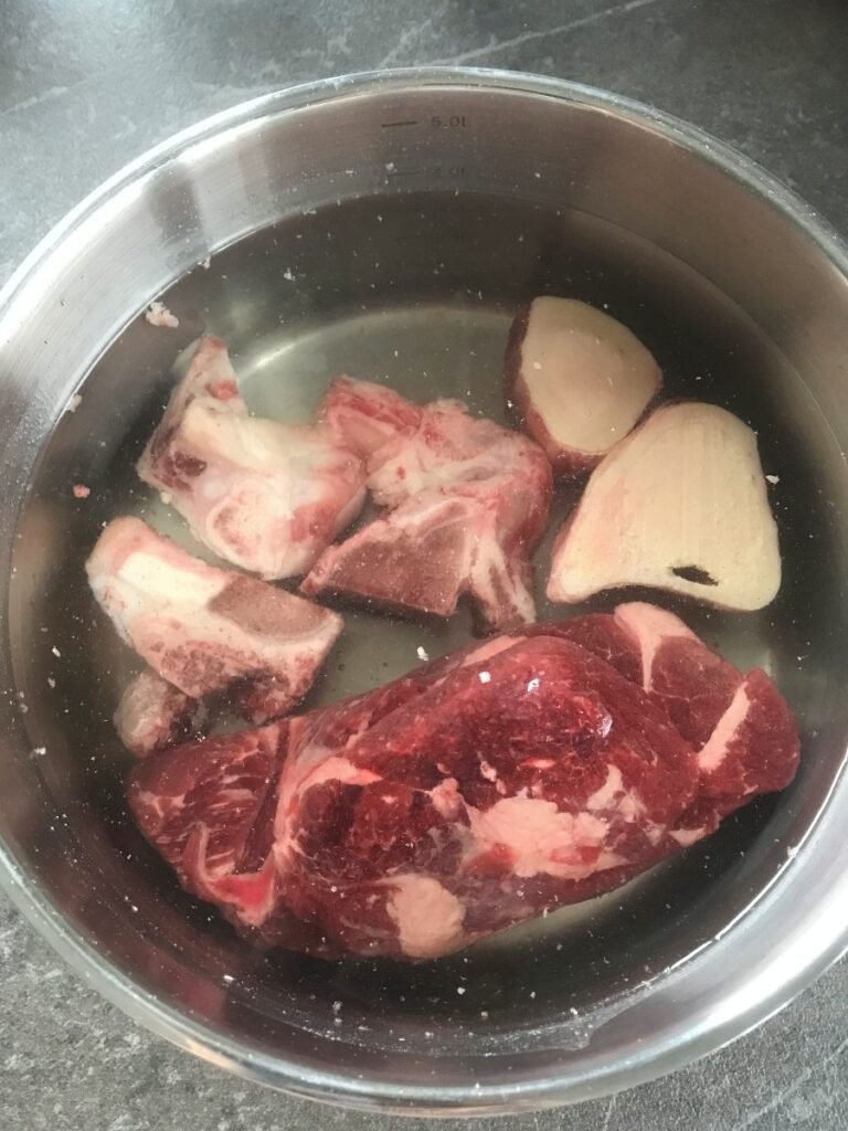 Beef and bones in a pot with water