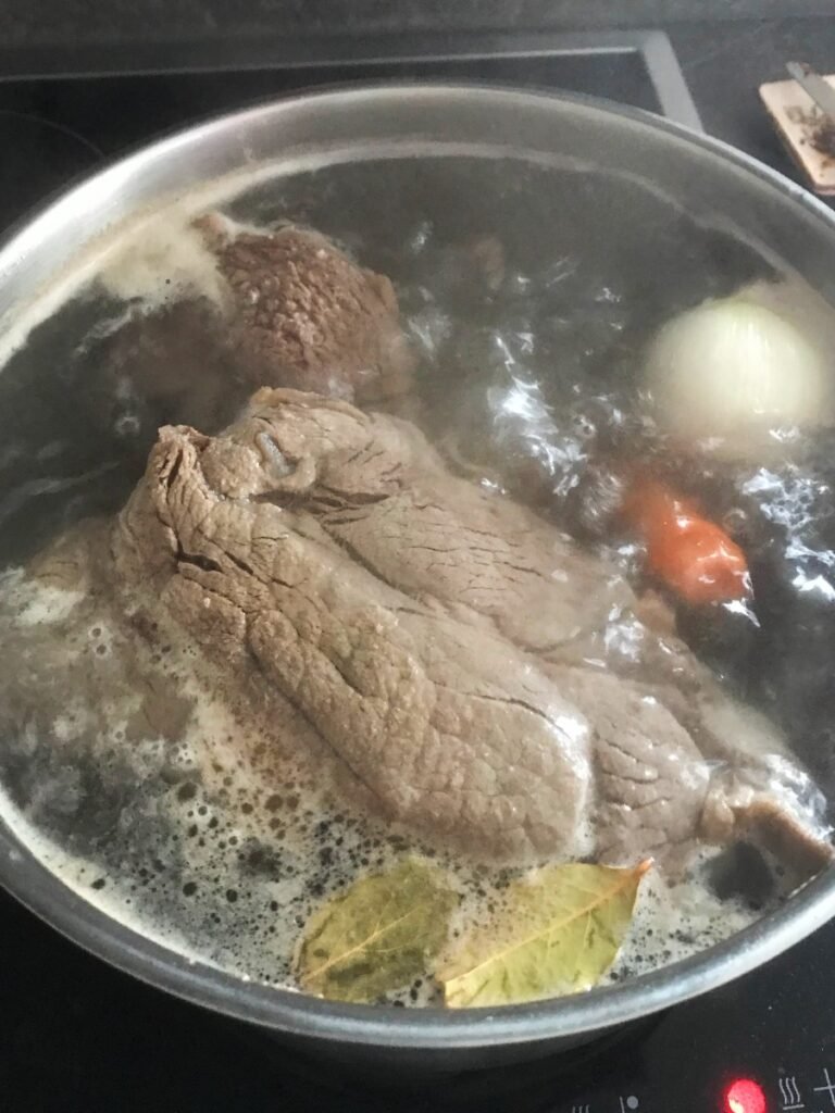 Beef bone broth cooking in a pot