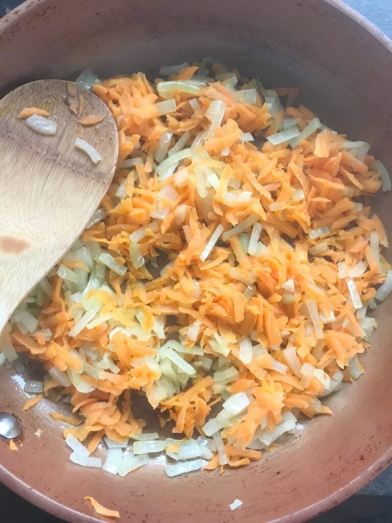 Carrots and onion sauteed in a skillet