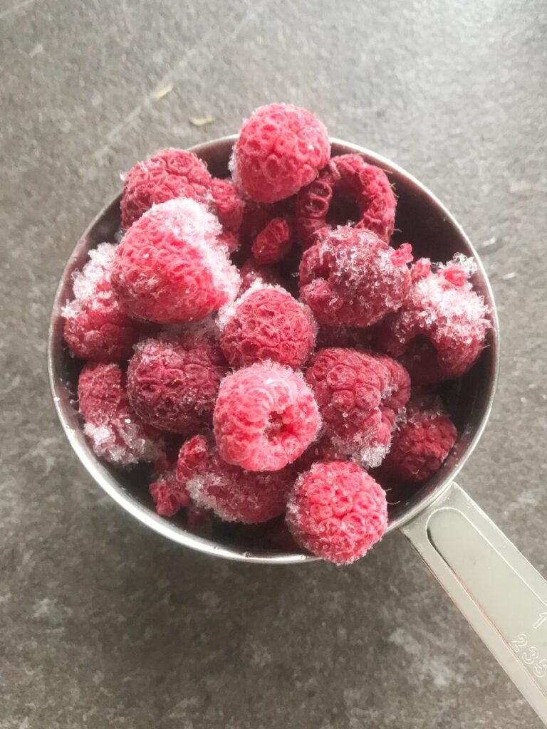 Frozen raspberries in a measuring cup