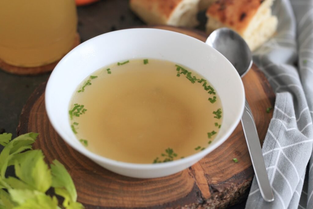 Beef bone broth in a bowl garnished with green onions