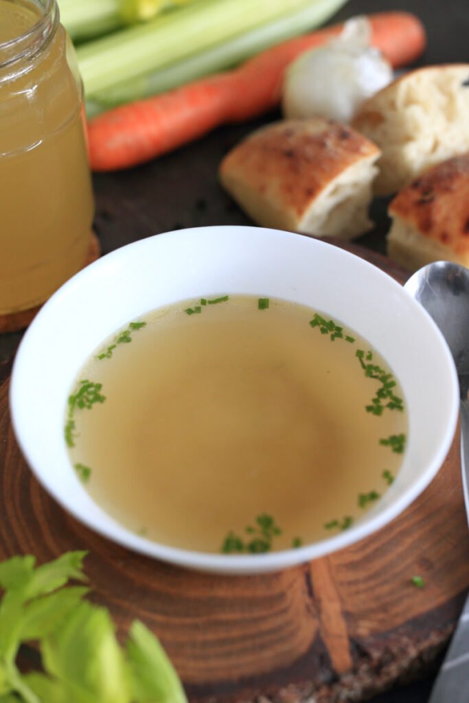 Beef bone broth in a bowl garnished with green onions