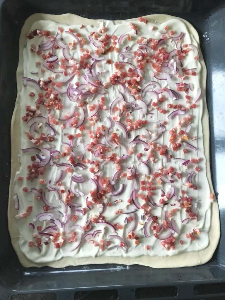 Flammkuchen with toppings ready to bake