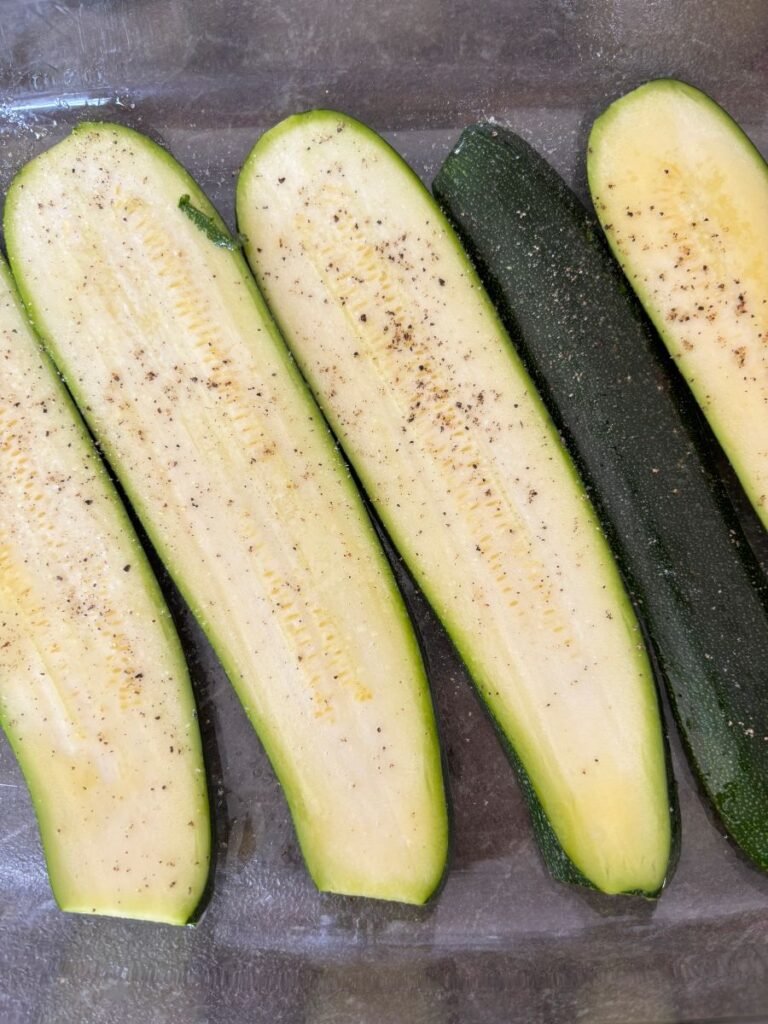 Sliced zucchini seasoned in a casserole dish